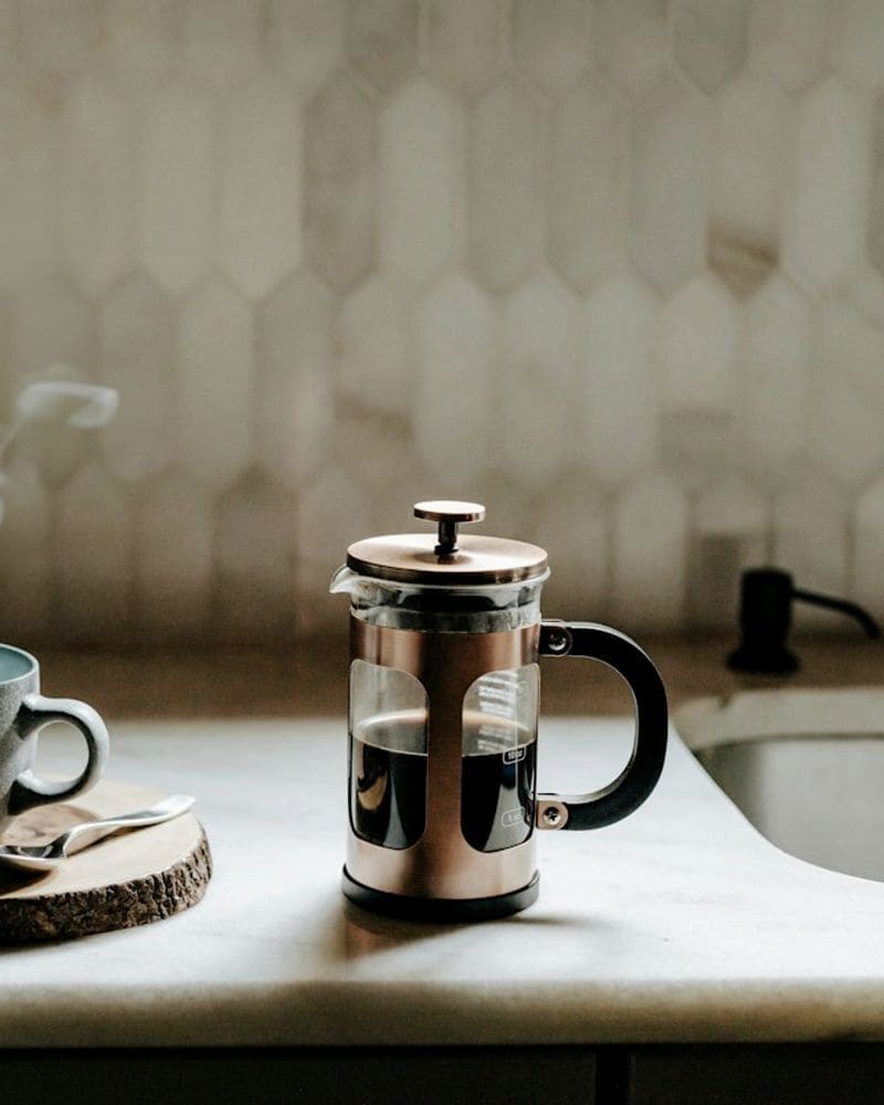 Чашка с паром и френч-пресс на кухонной стойке, кадр из соцсетей